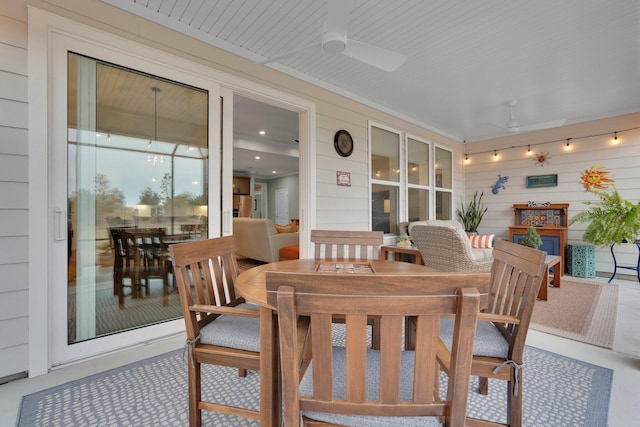 dining area featuring ceiling fan and wood walls