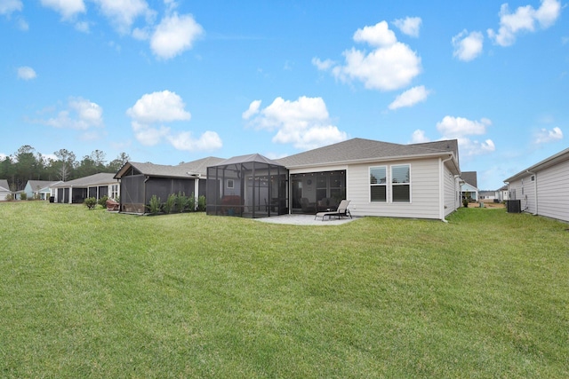 rear view of house with a yard, a patio, central AC unit, and a lanai