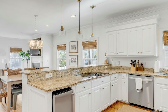 kitchen with black electric stovetop, a peninsula, stainless steel dishwasher, a wealth of natural light, and crown molding