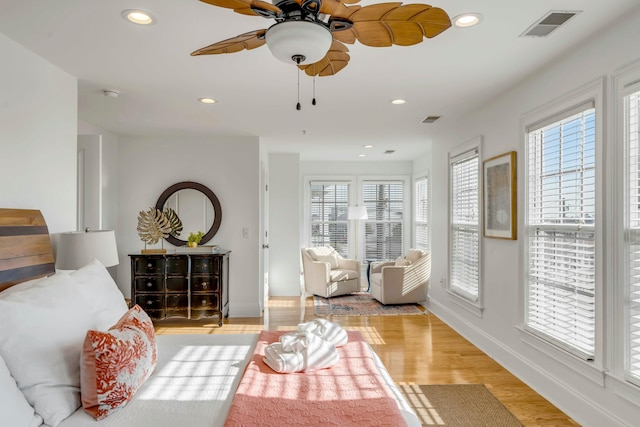 living room featuring baseboards, light wood-style flooring, visible vents, and recessed lighting