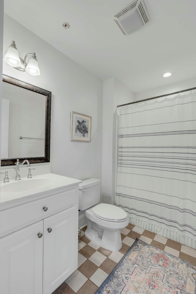 bathroom featuring visible vents, vanity, toilet, and tile patterned floors