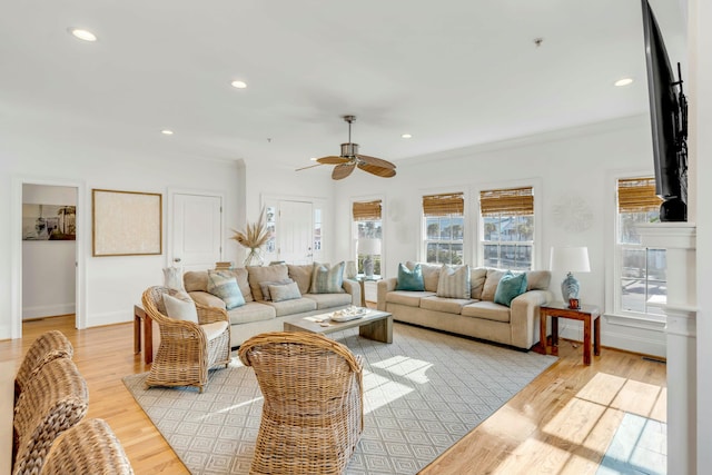 living room featuring light wood-type flooring, ornamental molding, a wealth of natural light, and recessed lighting