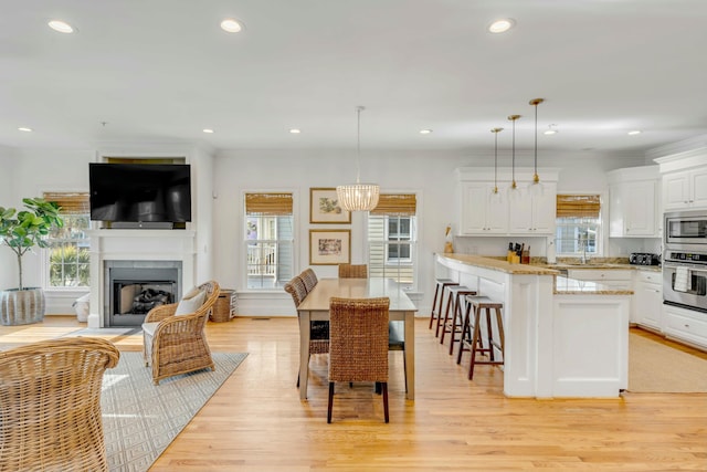 interior space featuring plenty of natural light, a fireplace with flush hearth, and light wood-style flooring