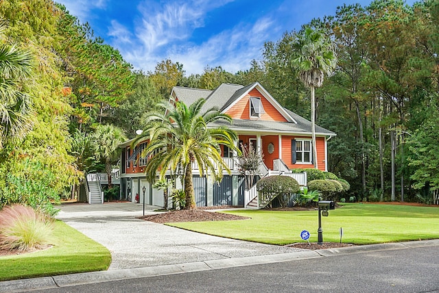 view of front of property with covered porch, a garage, and a front lawn