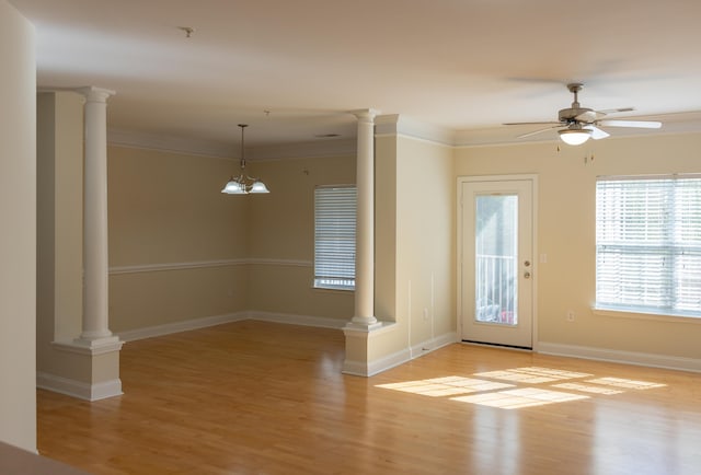 interior space featuring decorative columns, light wood-style flooring, and crown molding