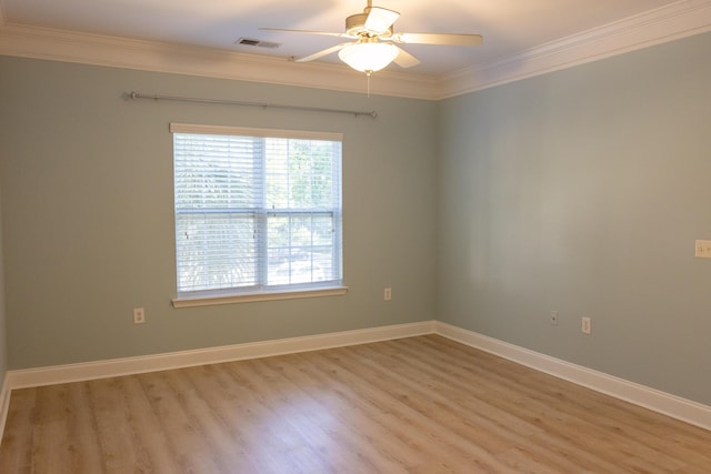 spare room with baseboards, visible vents, and crown molding