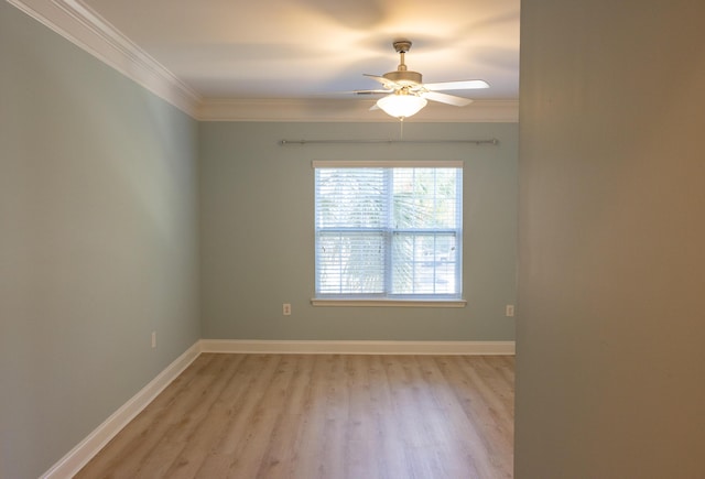 empty room featuring ornamental molding, light wood-type flooring, a ceiling fan, and baseboards