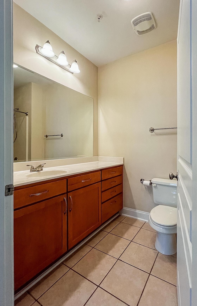 full bathroom featuring toilet, vanity, baseboards, visible vents, and tile patterned floors