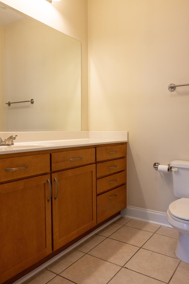 bathroom featuring baseboards, vanity, toilet, and tile patterned floors