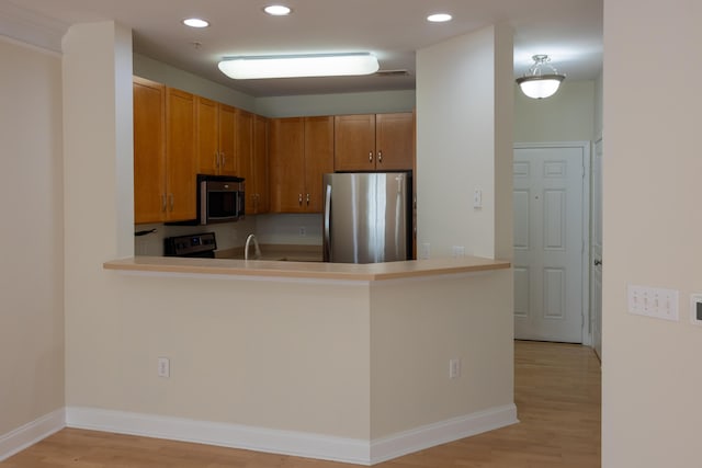 kitchen featuring appliances with stainless steel finishes, recessed lighting, and light wood finished floors