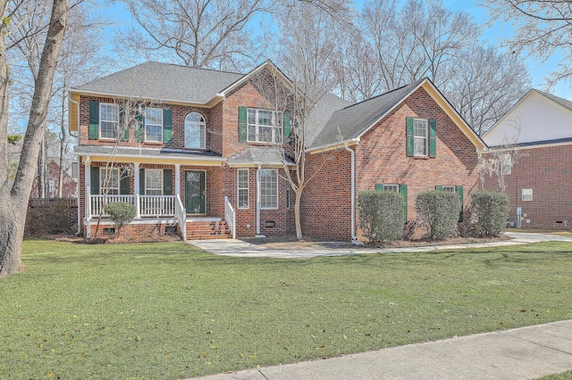 view of front of home with brick siding, roof with shingles, covered porch, a front yard, and crawl space