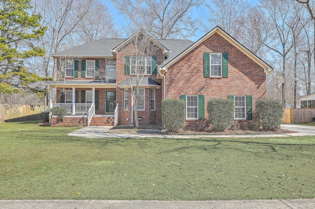 view of front of home featuring a porch, a front yard, fence, and brick siding