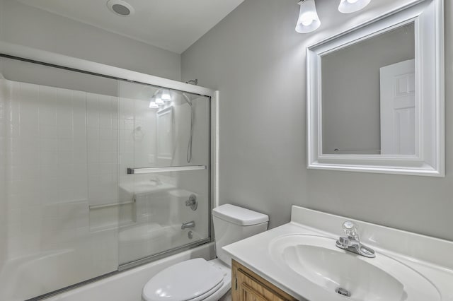 bathroom with vanity, toilet, and bath / shower combo with glass door