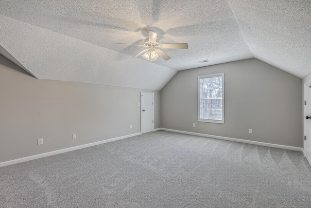 additional living space featuring lofted ceiling, carpet flooring, and visible vents