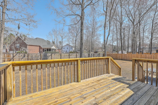 wooden terrace featuring a residential view and a fenced backyard