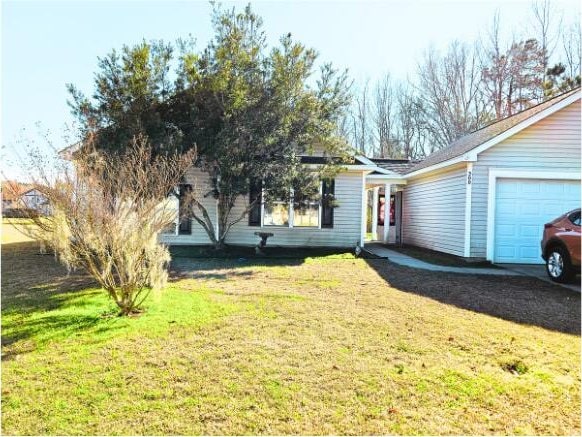 view of front of home featuring an attached garage and a front yard