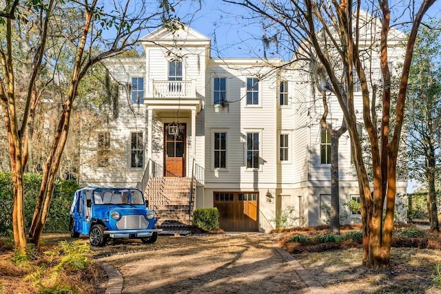 view of front of property with a garage and dirt driveway