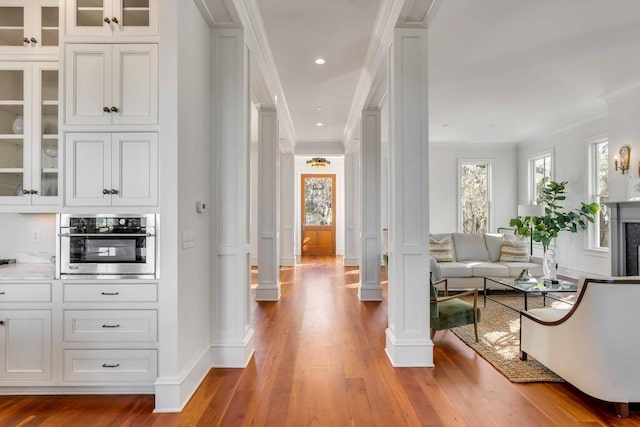 interior space featuring ornamental molding, a wealth of natural light, oven, and ornate columns