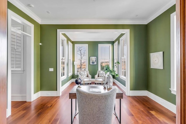 sitting room with crown molding, baseboards, and wood finished floors