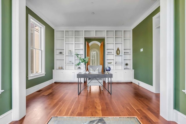 office space with ornamental molding, wood finished floors, and baseboards