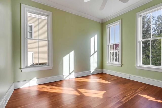 spare room with ceiling fan, crown molding, baseboards, and wood finished floors