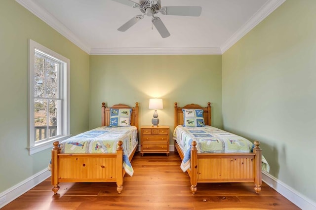 bedroom featuring baseboards, ornamental molding, ceiling fan, and wood finished floors