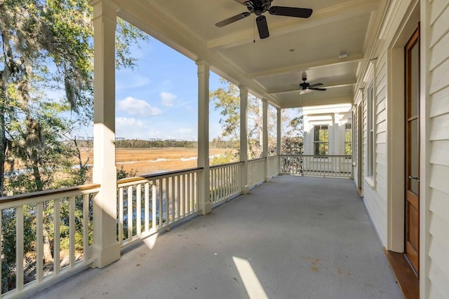 view of patio / terrace with a porch, a ceiling fan, and a rural view