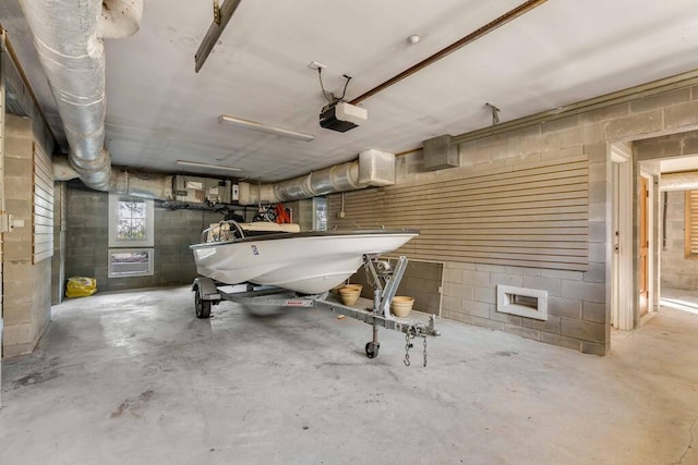 garage featuring concrete block wall and a garage door opener