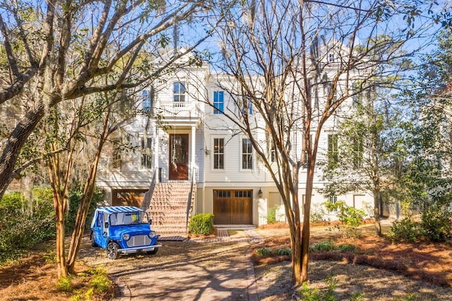 view of front of house featuring driveway, an attached garage, and stairway