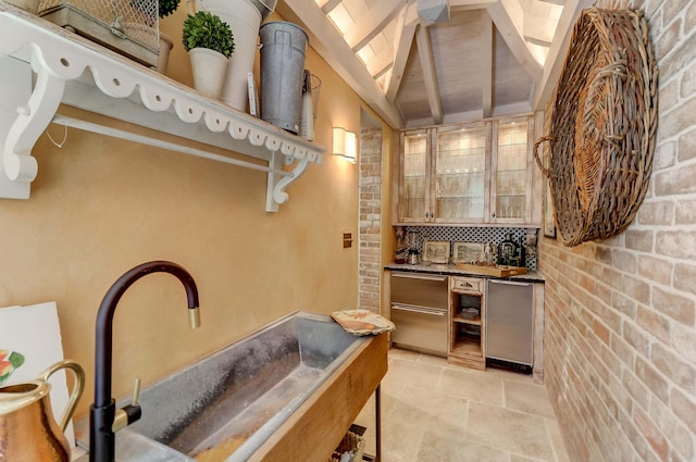 interior space featuring brick wall, wet bar, and lofted ceiling