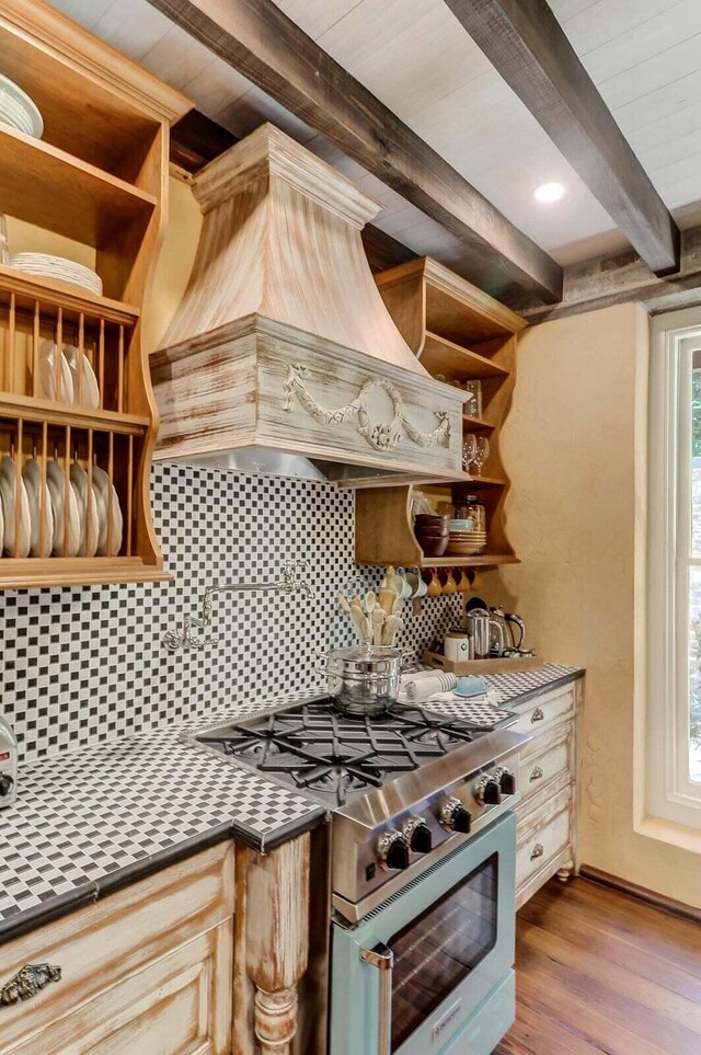 kitchen featuring premium range hood, gas stove, tasteful backsplash, light wood-type flooring, and beamed ceiling