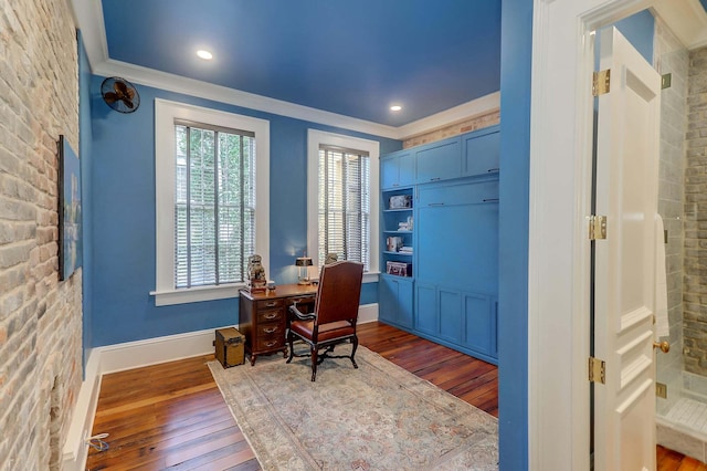 office space featuring crown molding, wood-type flooring, and brick wall