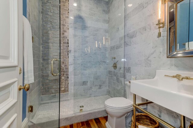 bathroom featuring tile walls, an enclosed shower, hardwood / wood-style flooring, and toilet