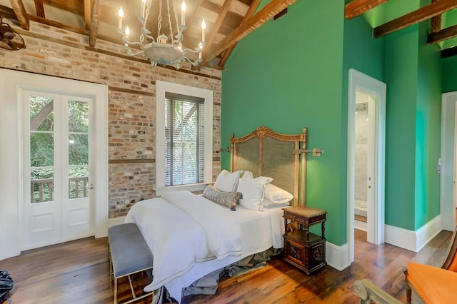 bedroom featuring vaulted ceiling with beams, brick wall, hardwood / wood-style floors, and a notable chandelier