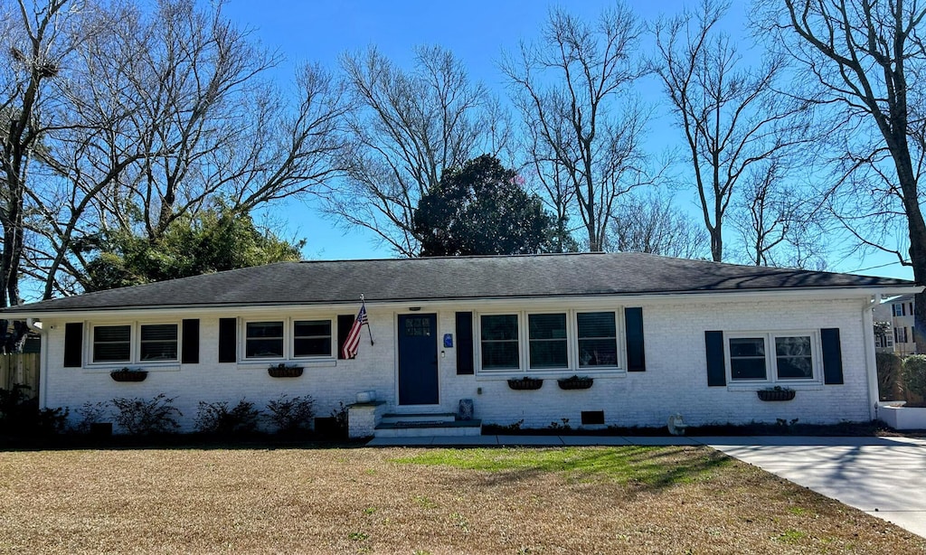 ranch-style house with crawl space, brick siding, and a front lawn