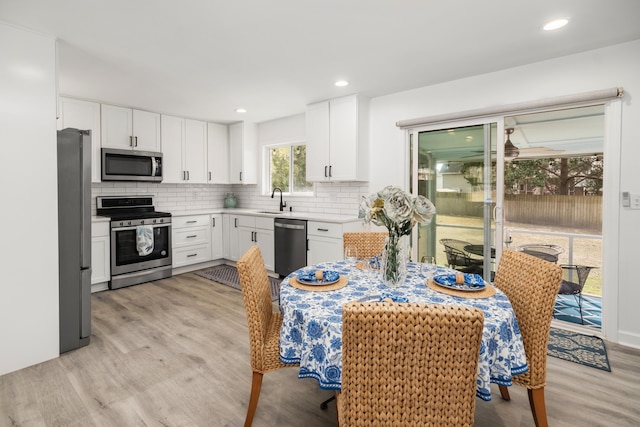 2137 Barbour Dr, Charleston, SC 29414 - kitchen with tasteful backsplash, light wood-style flooring, white cabinets, stainless steel appliances, and a sink