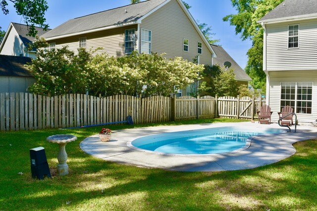 view of swimming pool with a lawn, fence, a patio area, and a fenced in pool
