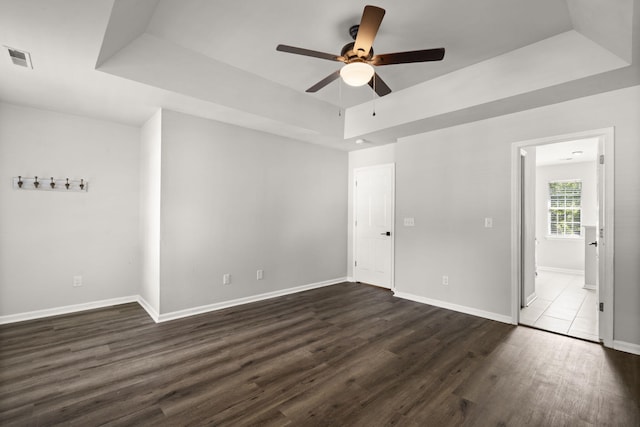 132 E Hartwick Ln, Goose Creek, SC 29445 - unfurnished bedroom featuring baseboards, visible vents, dark wood-style floors, and a raised ceiling