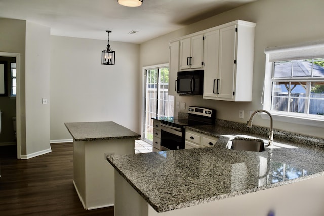 kitchen featuring a sink, black microwave, a center island, white cabinetry, and electric stove