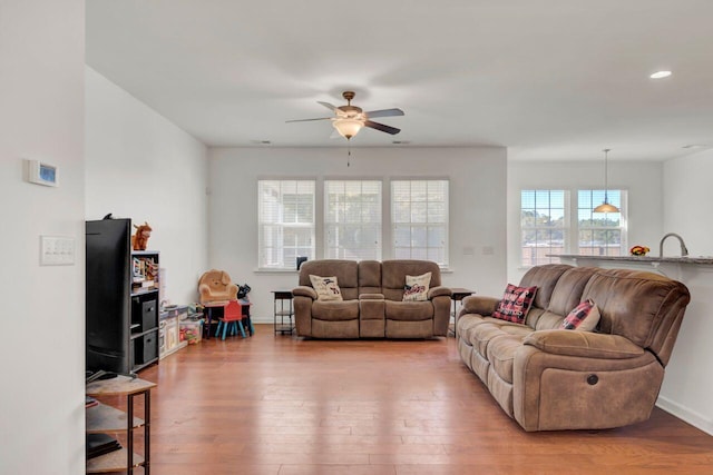 living room featuring wood-type flooring and ceiling fan