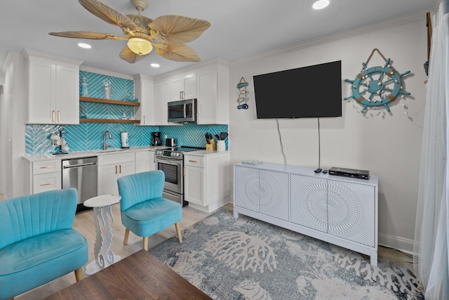 kitchen featuring stainless steel appliances, tasteful backsplash, a sink, and white cabinets