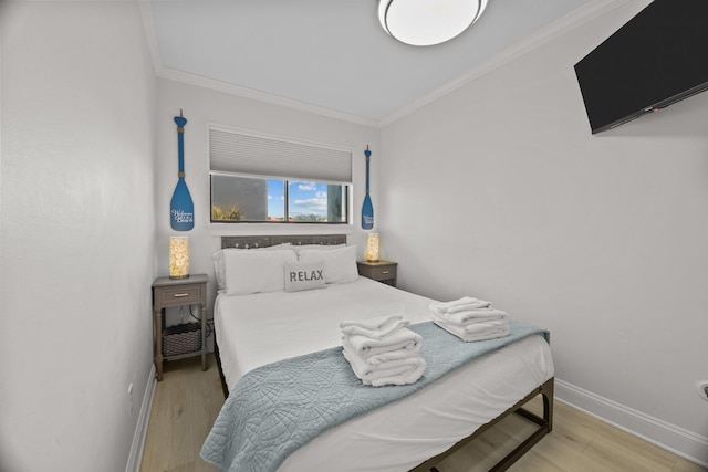 bedroom featuring ornamental molding, baseboards, and wood finished floors