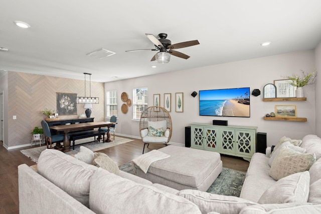 living room featuring dark hardwood / wood-style flooring and ceiling fan with notable chandelier