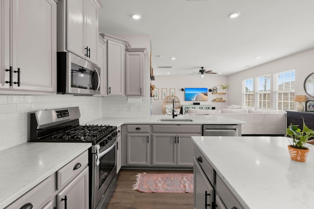 kitchen with stainless steel appliances, ceiling fan, gray cabinetry, and sink