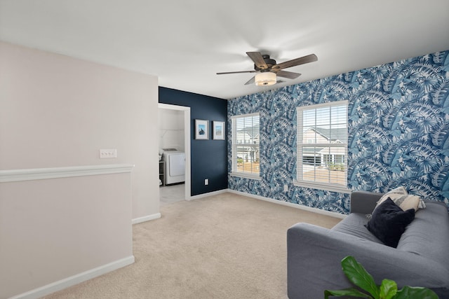 living room featuring washer / clothes dryer, ceiling fan, and light colored carpet