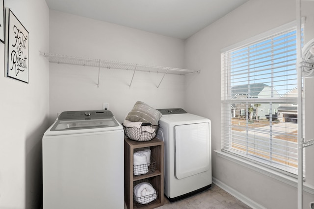 laundry area featuring separate washer and dryer and plenty of natural light