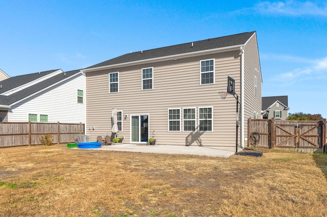 rear view of house featuring a lawn and a patio