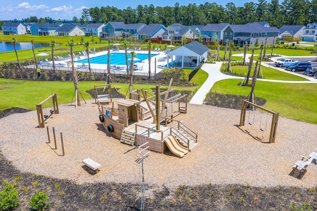 exterior space with a playground, a pool, a lawn, and a water view