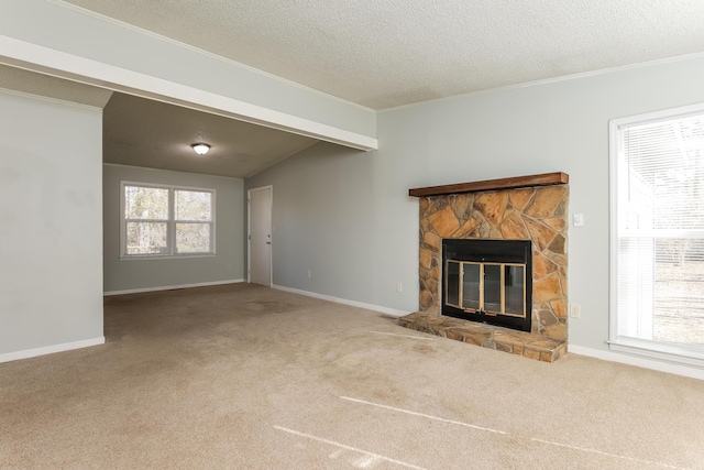 unfurnished living room with beamed ceiling, a stone fireplace, carpet floors, and a textured ceiling