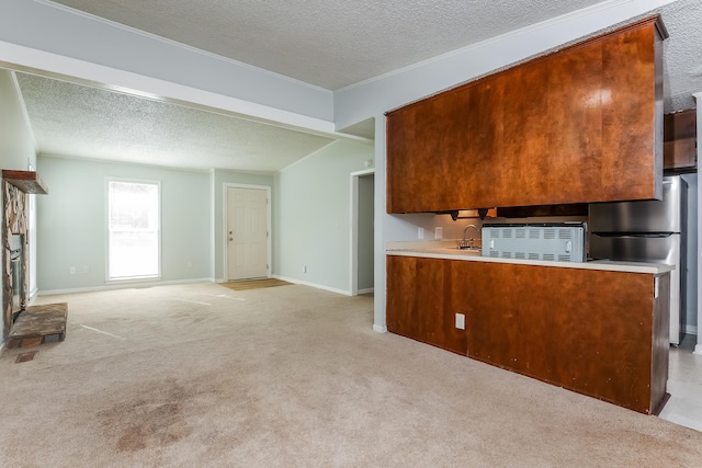 kitchen with kitchen peninsula, stainless steel fridge, a textured ceiling, and light colored carpet